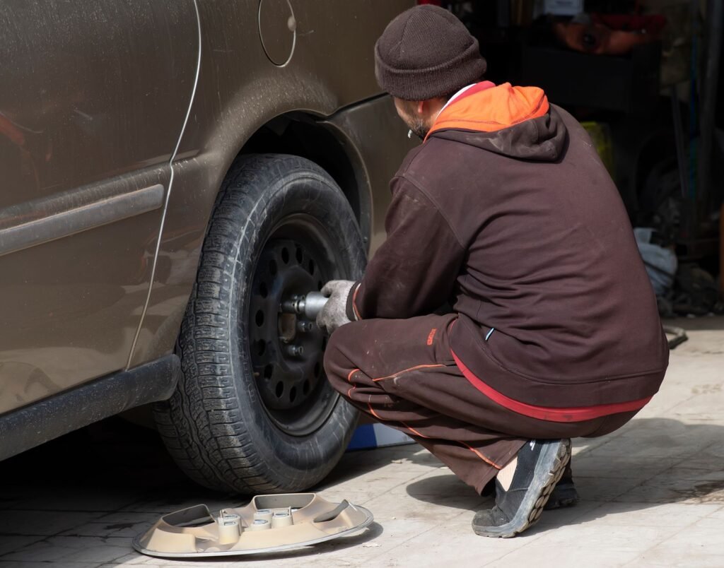 Mécanicien qui change la roue d'une voiture